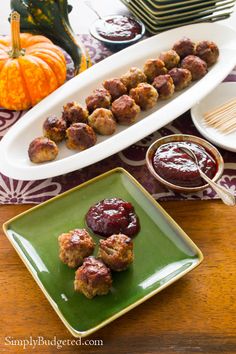 meatballs on skewers with cranberry sauce and pumpkins in the background