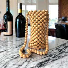 a wooden beaded bag sitting on top of a counter next to bottles of wine