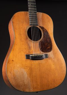 an old wooden guitar that is on display