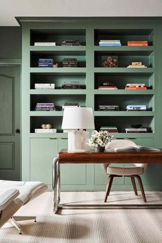 a room with green bookshelves and a wooden table