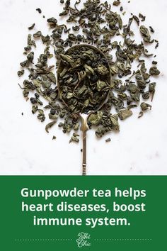 a spoon filled with green tea leaves on top of a white table