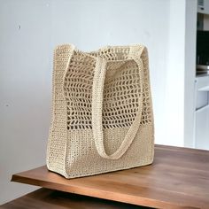 a beige bag sitting on top of a wooden table next to a white refrigerator freezer