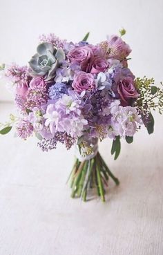 a bouquet of purple flowers sitting on top of a table