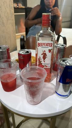 a table topped with glasses and bottles of alcohol on top of a white tablecloth