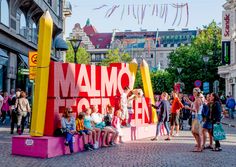 a group of people standing on top of a pink sign