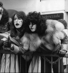 three people dressed in costumes and makeup posing for a photo on the balcony of a building