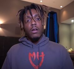 a young man with dreadlocks standing in front of a mirror and looking at the camera