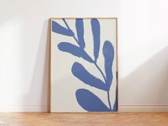 a blue and white painting sitting on top of a hard wood floor