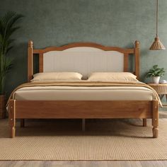 a bed sitting on top of a wooden floor next to a plant