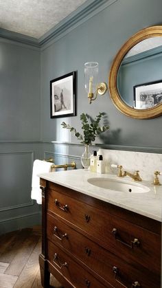 a bathroom with blue walls and wood floors