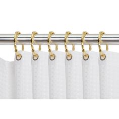 white curtains with gold hardware hanging from the curtain rod