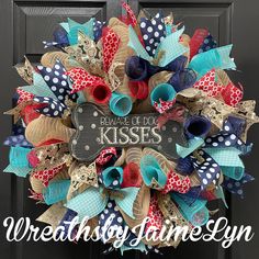 a wreath that says beware of the kisses with red, white and blue bows