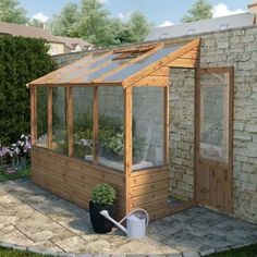 a small wooden greenhouse with plants in it