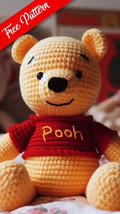 a crocheted teddy bear wearing a red shirt with the word pooh on it