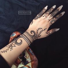 a woman's hand with henna tattoos on it