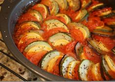 sliced zucchini and tomatoes in a pan with seasoning