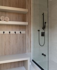 a bathroom with a shower, shelves and towel racks