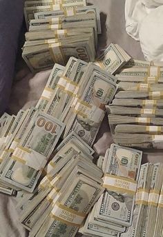 a pile of money sitting on top of a bed