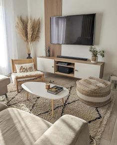 a living room filled with furniture and a flat screen tv on top of a wall