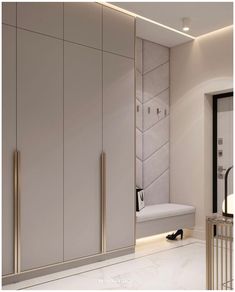 a white closet with gold handles and some shoes on the floor in front of it