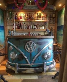 an old vw bus bar is painted blue and has lights on the ceiling above it