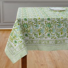 a green and white table cloth on top of a wooden table