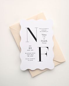 a wedding card with the letter nf in black and white, on top of an envelope