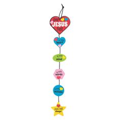 a colorful mobile with jesus first written in different languages on it's sides and stars attached to the strings