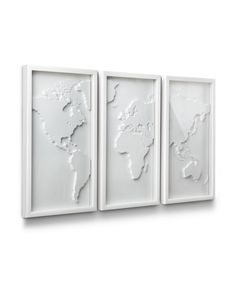 three white wall art pieces with the world map on one side and two smaller ones on the other