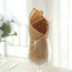 a wine glass sitting on top of a table next to a vase filled with flowers