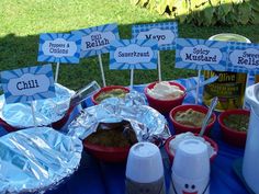 a table topped with lots of food covered in tin foil