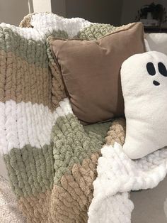 a blanket with a ghost face on it next to a pillow that has been made