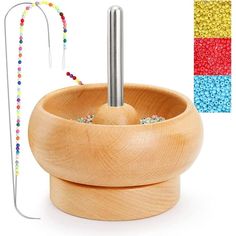 a wooden bowl with beads and a hook in the center, next to it's holder