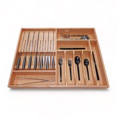 a wooden tray with utensils and spoons in it on a white background