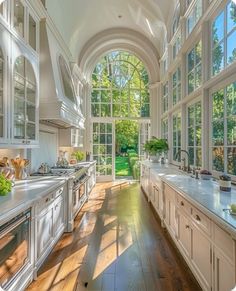 a large kitchen with lots of windows and white cabinets on both sides of the room