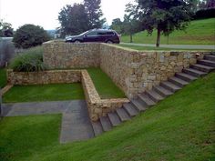 a car is parked on the side of a stone wall with steps leading up to it