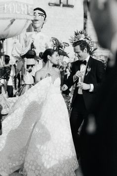 black and white photograph of bride and groom dancing in front of large group of people