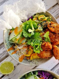 two bowls filled with food on top of a white wooden table next to each other