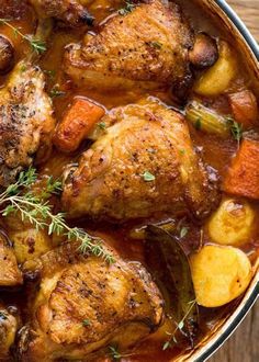 chicken stew with potatoes and carrots in a pot on a wooden table, ready to be eaten