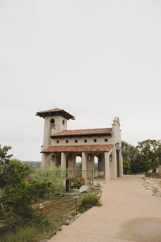 a large house with a tall tower on top of it's roof next to trees