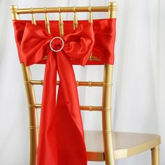 a chair with a red bow tied to it's back and the seat is gold