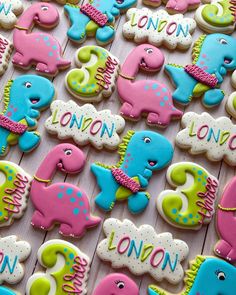 some decorated cookies are on a table with pink, blue and green ones in the shape of elephants