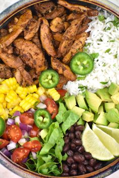 a bowl filled with chicken, rice, beans, avocado and other vegetables