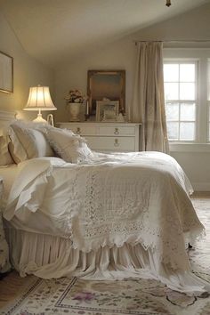 a white bed sitting in a bedroom next to a window