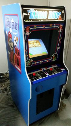 an old fashioned video game machine sitting on top of a floor next to a wall