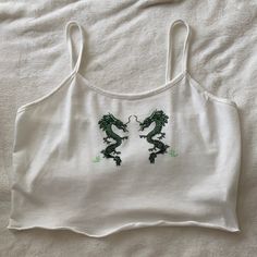 A Very Cute White Cropped Tank! With Two Detailed Green Dragons On It And Little Ruffles On The Bottom Of The Shirt. Never Worn. Size Large. White Y2k Cami Top, Y2k Style White Cami Top, White Y2k Style Crop Top For Spring, White Cami Top Y2k Style, White Y2k Tank Top For Spring, Y2k Style White Tank Top For Spring, Casual White Cami Crop Top, White Casual Crop Top For Spring, Green Dragons