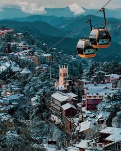 a ski lift with two people on it in the middle of a snowy mountain town