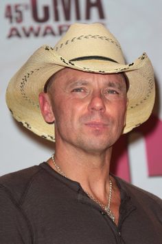 a man wearing a cowboy hat in front of a wall with the words'45 gima awards'written on it