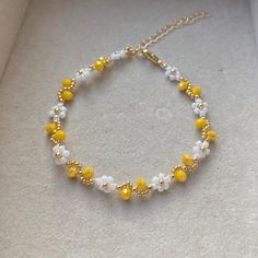 a yellow and white beaded bracelet sitting on top of a box