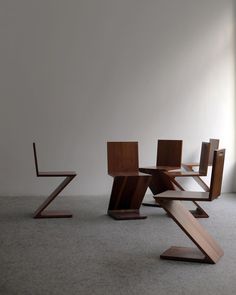 a group of wooden chairs sitting on top of a carpeted floor